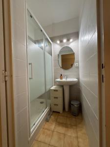 勒卡特海滩Appartement avec vue panoramique-Leucate Falaise的带玻璃淋浴和水槽的浴室