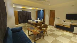 a hotel room with a bed and a living room at Hotel Prince Garden Daman in Daman