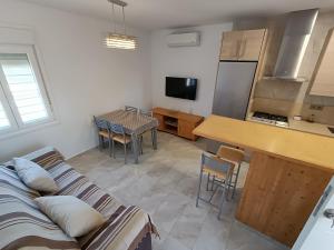 a living room with a couch and a table and a kitchen at Apartamento El Palmar, a 500 metros de la Playa in Vejer de la Frontera