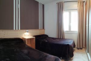 a hotel room with two beds and a mirror at Apartamento El Palmar, a 500 metros de la Playa in Vejer de la Frontera