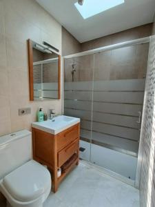 a bathroom with a toilet and a sink and a shower at Apartamento El Palmar, a 500 metros de la Playa in Vejer de la Frontera