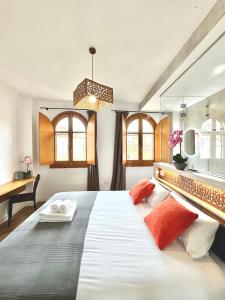 a bedroom with a large white bed with orange pillows at Unique House - Private SPA&Pool -StayInSeville in Seville