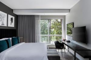 una camera da letto con un letto, una scrivania e una grande finestra di The Capital Empire a Johannesburg