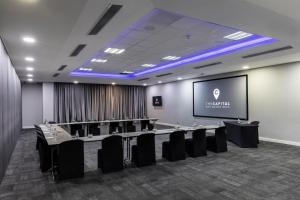 a conference room with tables and chairs and a screen at The Capital Empire in Johannesburg +79 photos