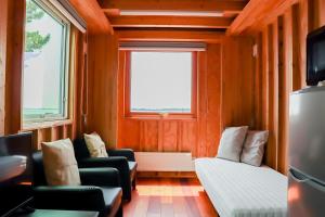 a small room with a couch and a bed and a window at kasumi terrace 霞ヶ浦 in Namegata
