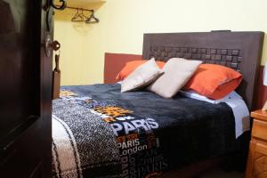 a bedroom with a bed with an orange and blue blanket at Habitación individual zona centro in Zacatlán +8 photos