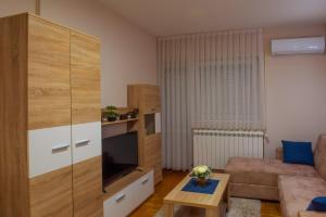 a living room with a couch and a large entertainment center at Apartman Happy day Valjevo in Valjevo