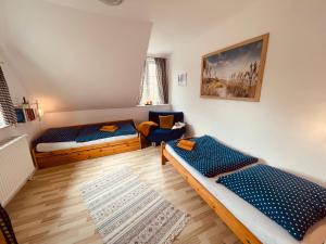ゲルティングにあるFerienhof Johannsen Ferienwohnung Weitblickのリビングルーム(ベッド2台、椅子付)