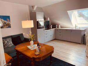 ゲルティングにあるFerienhof Johannsen Ferienwohnung Weitblickのテーブルとキッチンのあるリビングルーム