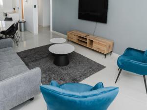 a living room with a couch and chairs and a tv at Romilly Beachfront 92 in Strand