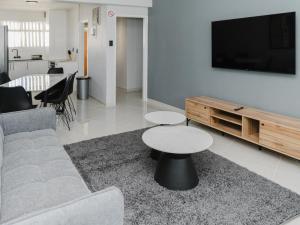 a living room with a couch and a table and a tv at Romilly Beachfront 92 in Strand