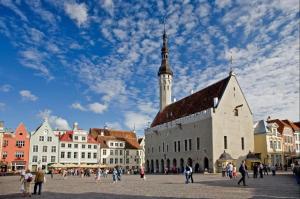 Un grupo de personas caminando por una ciudad con una iglesia. en Luxury apartment in the heart of Old Town, en Tallin