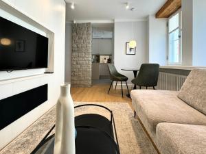 Una sala de estar con un sofá y un televisor. en Luxury apartment in the heart of Old Town, en Tallin