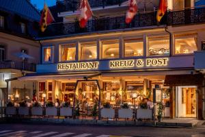 a restaurant in front of a building at night at Hotel Kreuz & Post Grindelwald in Grindelwald