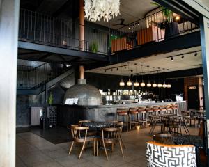 un ristorante con tavoli e sedie e un bar di Cityescapes 2F in Waterfall Midrand - Beautiful self catering 2 bedroom unit next to Kyalami Racetrack with free WiFi swimming pool gym and restaurant - Perfect for a small family a Midrand