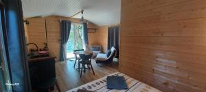 a bedroom with a bed and a table in a room at Le petit Chalet du MacQuart P.O.A. RANCH, 2 à 3 pers, in Saint-Martin-de-Fugères