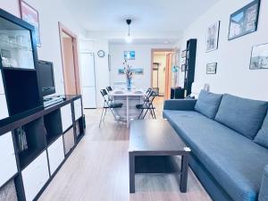a living room with a blue couch and a table at Apartamento Espata IX in Villanúa