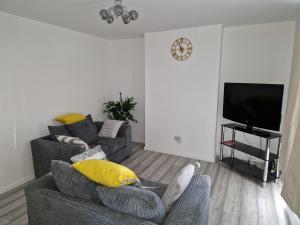 a living room with a couch and a tv at Large Swindon House Big Garden for Photoshoot in Swindon