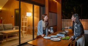 マナドにあるBobocabin Bunaken Hills, Manadoの部屋のテーブルの周りに立っている二人の女性