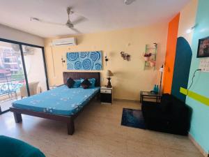 a bedroom with a bed and a chair in it at Neon Nirvana Deluxe Apartments in North Goa Near Calangute Candolim Anjuna in Nagoa-Bardez +33 photos