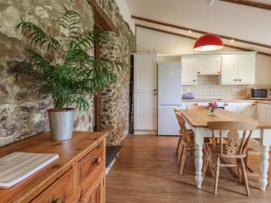 une cuisine et une salle à manger avec une table et une plante en pot dans l'établissement Weathervane Cottage, à Monkton