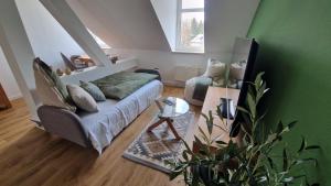 a living room with a couch and a chair at Grüne Oase am Küchwald in Chemnitz