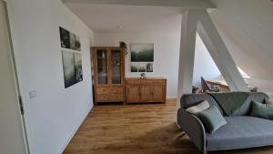 a living room with a couch and a dresser at Grüne Oase am Küchwald in Chemnitz +16 photos