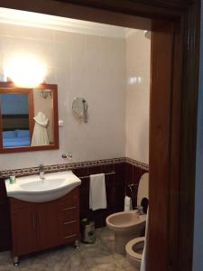 a bathroom with a sink and a toilet and a mirror at Hotel Sahel in Nouadhibou