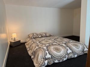 Un dormitorio con una cama grande en una habitación blanca. en OULLINS T3 COSY 70M2 - 6 Pers 2 Chambre - 2 Mezzanines Métro & centre à Pied, en Oullins 59 fotos más