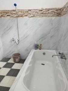 a white bath tub in a bathroom with a tiled floor at R & J Homestay in Naga Cebu in Tina-an +24 photos