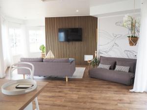 a living room with two couches and a tv at Tangalooma Life - 2 Bed 2 Bath Private Luxury Stay in Tangalooma