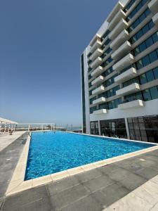 a swimming pool in front of a building at Elegant 2BR by Vendome mall in Lusail