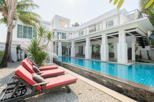 an exterior view of a villa with a swimming pool at Villas In Pattaya in Jomtien Beach +30 photos
