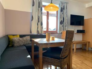 a living room with a table and a couch at Pension Kramerhof in Taufkirchen