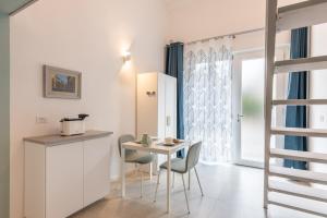 Una cocina y un comedor con mesa y sillas. en Alisea Tiny House by Pleiades Home, en Livorno