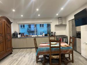 una cucina con un tavolo e sedie in una stanza di Les chambres de Marie a Didenheim Altre 31 foto