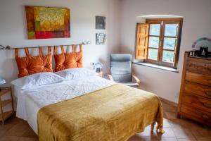 una camera da letto con un letto, una sedia e una finestra di Podere del Pari a Calci