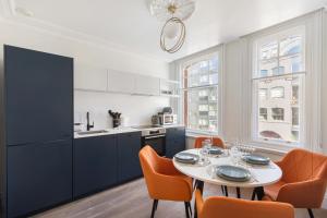 a kitchen with a table and orange chairs in a kitchen at HAFH in Farringdon- Stylish 1Bedroom Apartments in London