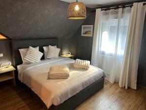 een slaapkamer met een groot bed en een raam bij L'écrin de la forêt in Jeanménil +23 foto's