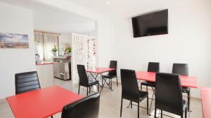 a dining room with red tables and black chairs at Hotel Paradís in Torredembarra