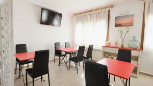 a dining room with red tables and black chairs at Hotel Paradís in Torredembarra