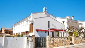 a white house with a fence in front of it at Hotel Paradís in Torredembarra