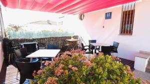 a patio with tables and chairs and plants at Hotel Paradís in Torredembarra