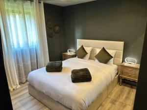 a bedroom with a large bed with two towels on it at L'écrin de la forêt in Jeanménil