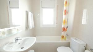 a white bathroom with a sink and a toilet at Hotel Paradís in Torredembarra
