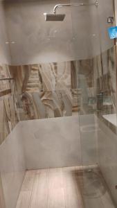 グルガオンにあるHigh-rise apartmentのバスルーム(ガラス張りのシャワー、シンク付)