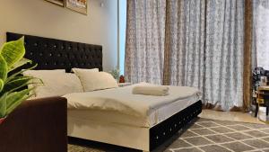 グルガオンにあるHigh-rise apartmentのベッドルーム1室(大型ベッド1台、黒いヘッドボード付) +35枚の写真