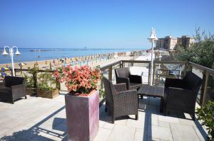 a patio with chairs and a view of the beach at Grand Hotel Azzurra Club in Lido Adriano