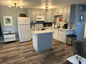 a kitchen with white cabinets and a white refrigerator at Casada in Las Vegas