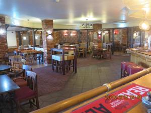 a restaurant with tables and chairs and a bar at Oyster Fleet Hotel in Canvey Island